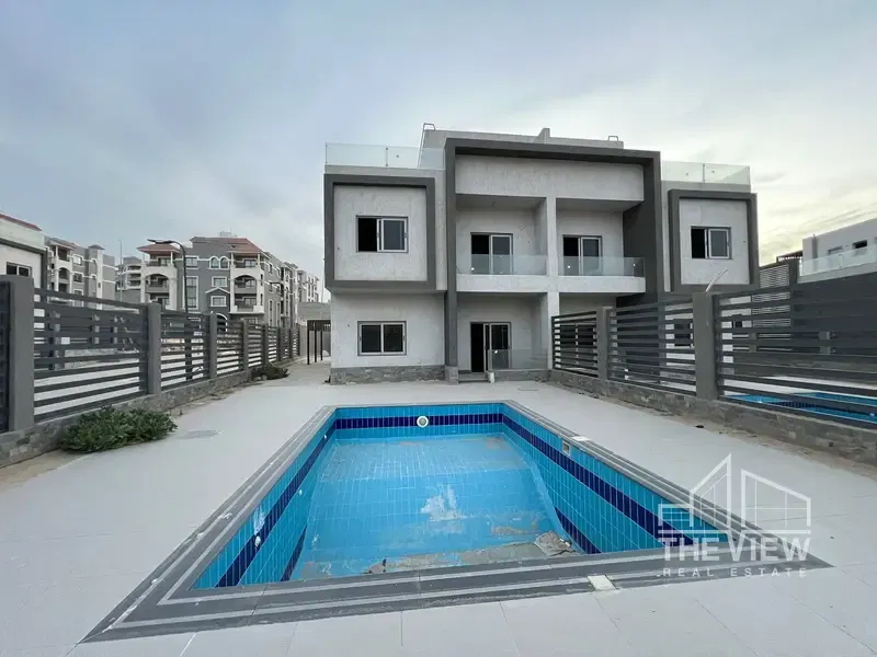 Twin House with ground property and a wonderful view in Al-Khomayel Compound, Sheikh Zayed, in front of Hyper One, View Zayed, semi-finished, immediate delivery.